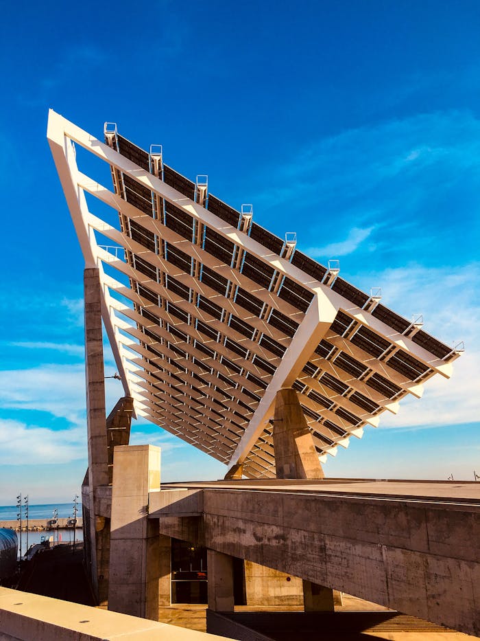 Photograph of a large solar panel installation set against a clear blue sky, highlighting renewable energy.